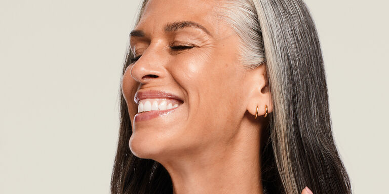 Mujer madura con piel luminosa sonriendo.
