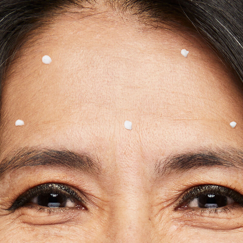 Close-up image of Dynamic Wrinkle Limiter placed in dots throughout forehead of mature brunette woman with smiling eyes