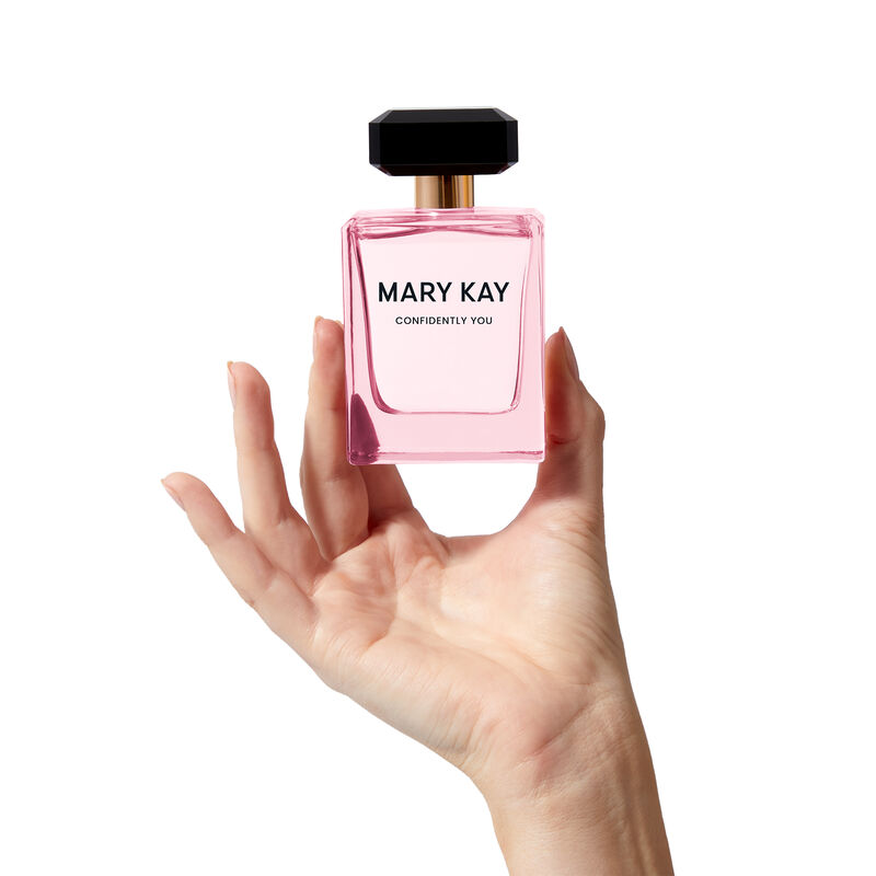 The light pink Mary Kay&reg; Confidently You&trade; bottle is held heroically by a hand.