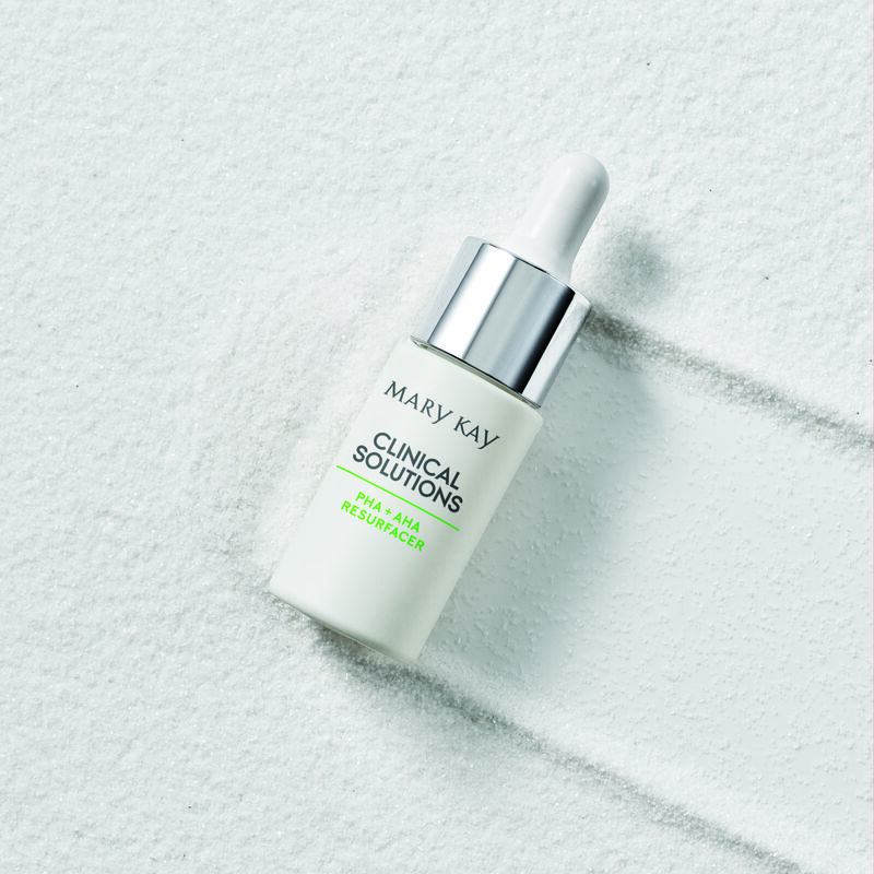 Closed bottle of Mary Kay Clinical Solutions PHA + AHA Resurfacer atop granular texture