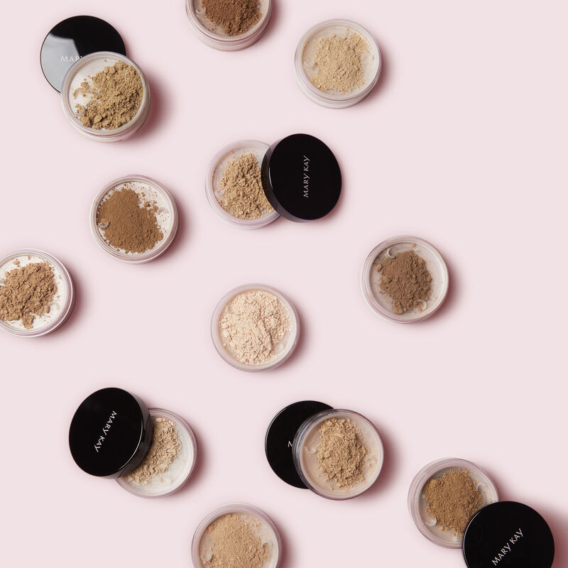 Open jars of Mary Kay Silky Setting Powder against pink background.