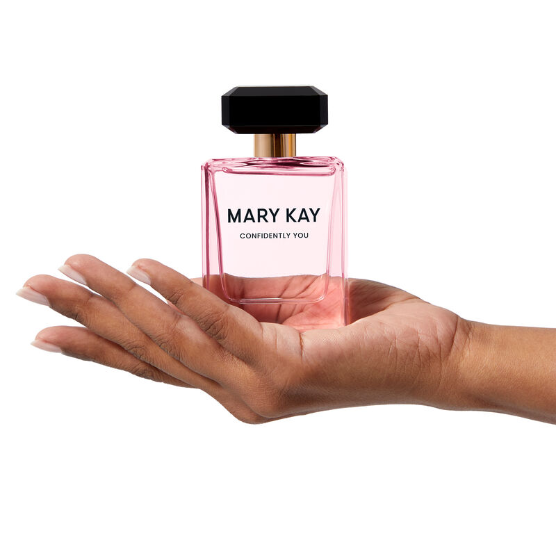 The light pink Mary Kay&reg; Confidently You&trade; bottle is held heroically by a hand.