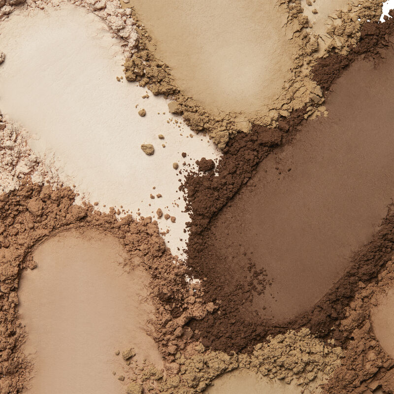 Product rubs of Mary Kay Silky Setting Powder in shades ranging across ivory, beige and bronze.