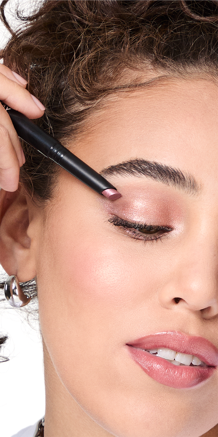 Modelo aplic&aacute;ndose Sombra con Brillos para Ojos en Barra Mary Kay&reg; en su p&aacute;rpado.