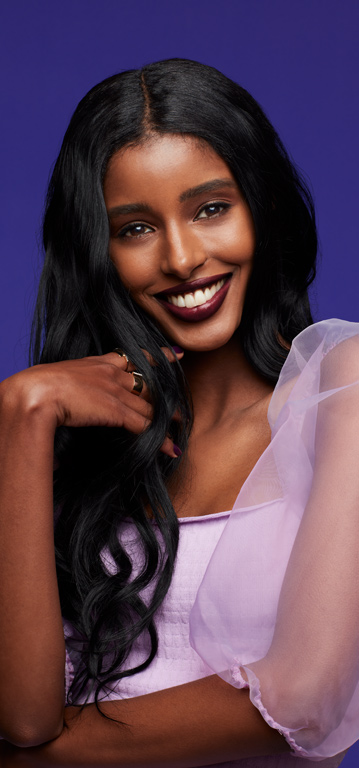 Mujer sonriendo a la c&aacute;mara usando un tono profundo de L&aacute;piz Labial Hidratante Mary Kay&reg; Supreme