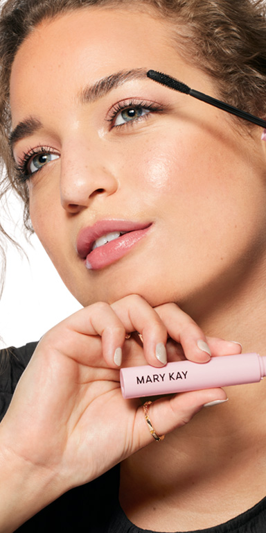 Model posing with a tube of Mary Kay Great Heights Mascara