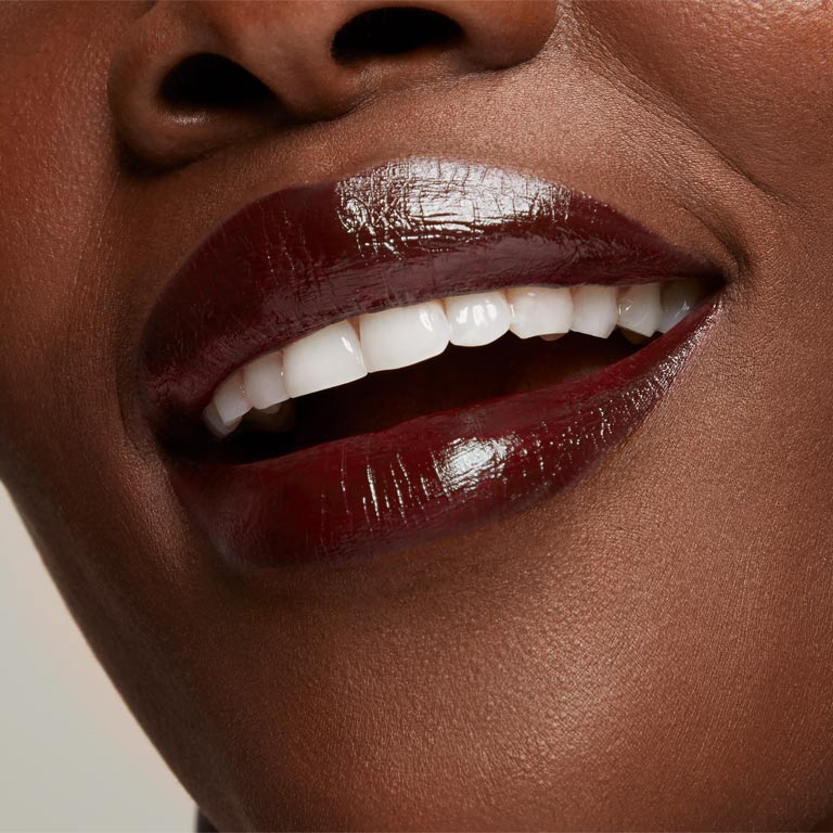 Acercamiento a labios de mujer usando un tono profundo de L&aacute;piz Labial Hidratante Mary Kay&reg; Supreme